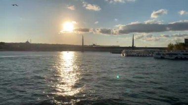 4K Tur gemisi İstanbul 'un günbatımındaki çarpıcı panoramik manzarasına bakan İstanbul Boğazı' nın zümrüt lagünü boyunca ilerliyor.