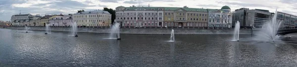 Moskau, Russland - August 2020: Schöne farbige alte Häuser am Kadaschewskaja-Damm und Wasserfontänen am Wodootwodny-Kanal in Moskau an einem sonnigen Tag, panoramisches Stadtbild — Stockfoto