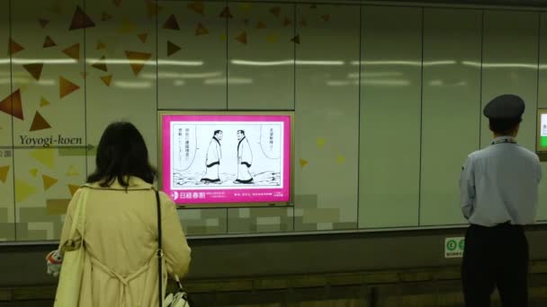 日本东京 2018年4月21日 东京地铁Meiji Jingumae Harajuku车站 年轻女子和一名月台服务员Oshiya在月台等候列车进站 — 图库视频影像