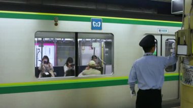 Tokyo / Japonya - 21 Nisan 2018: Tokyo Metro metrosunun Meiji-jingumae Harajuku istasyonunda çalışan Platform görevlisi Oshiya