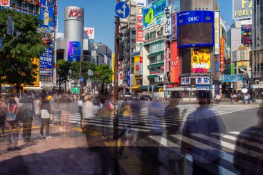 Tokyo / Japonya - 20 Nisan 2018: Tokyo, Japonya 'daki ünlü Shibuya kavşağından geçerken hareket halindeki insanlar bulanıklaştı