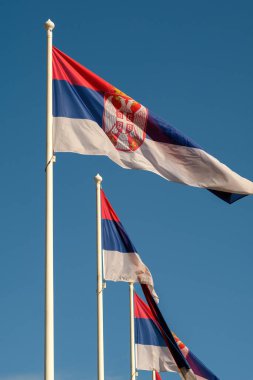 Sırbistan Cumhuriyeti bayrakları açık mavi gökyüzüne karşı