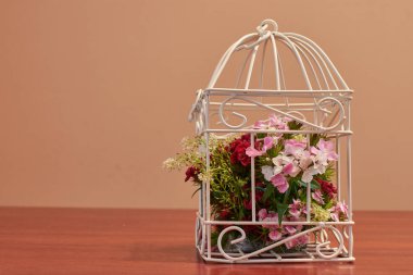 Çiçek buketi, kuş kafesi çiçek aranjmanı ve yanan mumla klasik düğün süsleri.