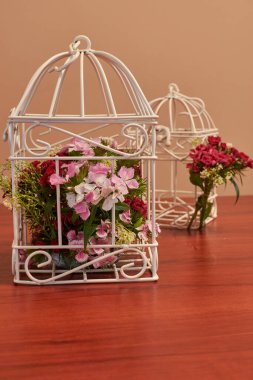 Çiçek buketi, kuş kafesi çiçek aranjmanı ve yanan mumla klasik düğün süsleri.