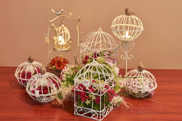 Bouquet of flowers, bird cage flower arrangement and vintage wedding decorations with burning candle