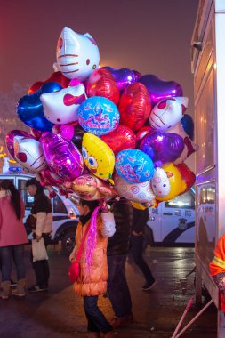Luoyang, Henan Eyaleti / Çin - 3 Ocak 2016: Luoyang, Çin 'de helyum dolu balon satan kadın