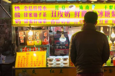 Luoyang, Henan Eyaleti / Çin - 3 Ocak 2016: Luoyang Eski Kenti 'ndeki bir sokak yemekhanesinden atıştırmalık alan adam