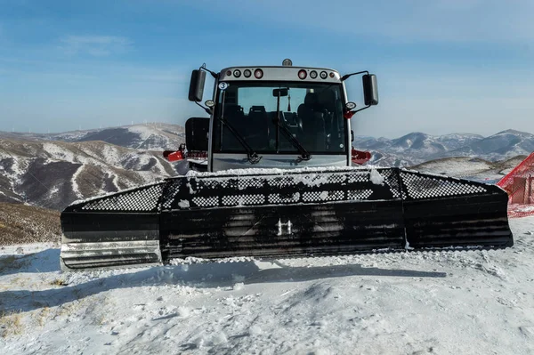 Bulldozer plowing snow at Genting Olympic resort, snowy mountain resort in Zhangjiakou, China, which will host skiing and snowboarding events for Beijing Winter Olympics 2022