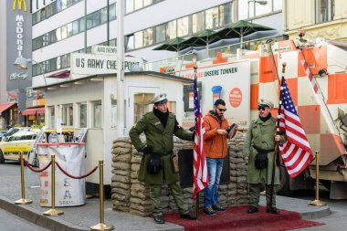 Berlin / Almanya - 15 Şubat 2017: Soğuk Savaş sırasında Doğu Berlin ile Batı Berlin arasındaki en bilinen Berlin Duvarı sınır kapısı olan Charlie Kontrol Noktasında fotoğraf çeken turist