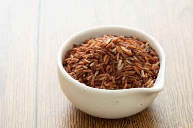 kahverengi pirinç için ahşap arka plan üzerinde sağlıklı beyaz kase