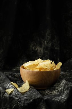 şişman ama lezzetli Aperatif sağlıksız nedeninin ahşap arka plan üzerinde ahşap kase gevrek patates cipsi