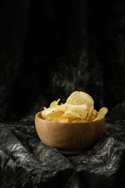 şişman ama lezzetli Aperatif sağlıksız nedeninin ahşap arka plan üzerinde ahşap kase gevrek patates cipsi