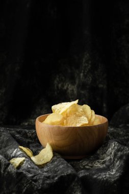 şişman ama lezzetli Aperatif sağlıksız nedeninin ahşap arka plan üzerinde ahşap kase gevrek patates cipsi