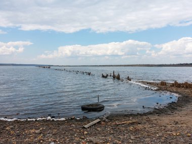Tuzlu Haliç Kuyalnik, ölü göl kenarında Odessa, Ukrayna. Ahşap sopa güneşli hava, mavi su yansıması. 