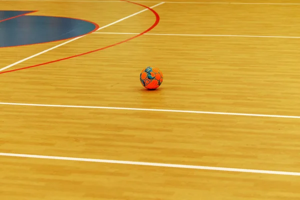 Gym for playing futsal, mini-football. Folded wooden parquet on the field of hall for mini-football. Futsal ball and bright line markings on the floor. Floor sports hall with bright lines of marking