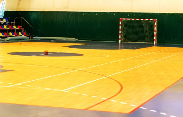 Futsal oynamak için spor salonu, mini-futbol. Salon sahasında mini futbol için katlanmış ahşap parke. Futsal top ve yerde parlak çizgiler. Parlak çizgileri olan spor salonu.