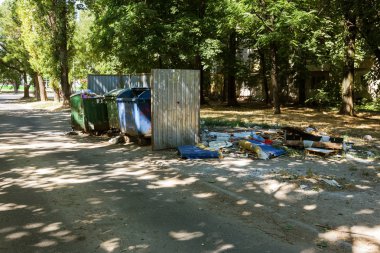 Çöp konteyneri, çöp ile kalabalık. Yolda terkedilmiş katı ev çöp. Çevre kirliliği. Ekolojik sorun. Terk edilmiş çöp yolda. Büyük bir şehirde atık yönetimi sorunu