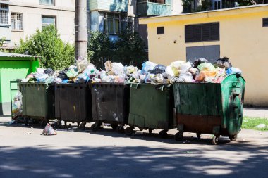 Çöp konteyneri, çöp ile kalabalık. Yolda terkedilmiş katı ev çöp. Çevre kirliliği. Ekolojik sorun. Terk edilmiş çöp yolda. Büyük bir şehirde atık yönetimi sorunu