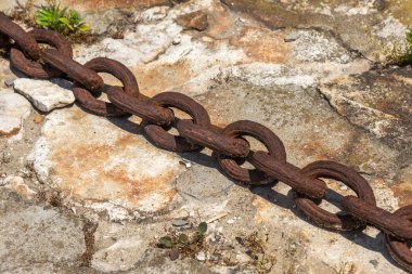 Eski paslı metal zinciri gemi demiri. Karadan denize giden dev ağır çelik zincir. Kargo gemisinin sarı halatı. Eski paslı deniz demir zinciri