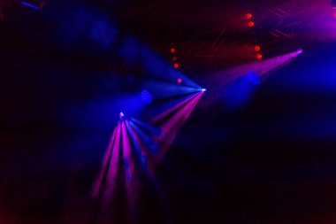 Sahne ışıkları. Bazı projektörler karanlıkta. Parlak renkli sahne ışığı karanlığı nüfuz eder. Işık aşamasından, rock konseri. Aydınlatma donanımları. Tiyatro aydınlatma sistemi üzerinde çeşitli projektörler