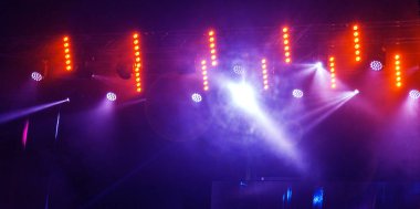 Sahne ışıkları. Bazı projektörler karanlıkta. Parlak renkli sahne ışığı karanlığı nüfuz eder. Işık aşamasından, rock konseri. Aydınlatma donanımları. Tiyatro aydınlatma sistemi üzerinde çeşitli projektörler