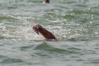 Yüzücü denizde yüzüyor. Atlet triatlet yüzücü sudan boşalmasına neden olur. Triathletes trenler bir Ironman için profesyonel bir atlet. Sporcu güzel yarışmalarda mavi deniz suda yüzer.