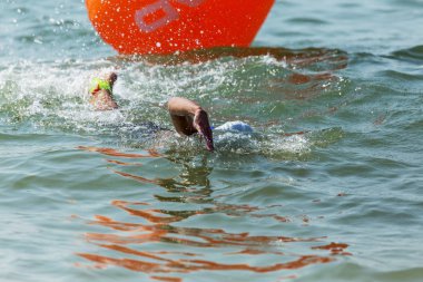 Yüzücü denizde yüzüyor. Atlet triatlet yüzücü sudan boşalmasına neden olur. Triathletes trenler bir Ironman için profesyonel bir atlet. Sporcu güzel yarışmalarda mavi deniz suda yüzer.