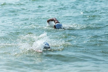 Yüzücü denizde yüzüyor. Atlet triatlet yüzücü sudan boşalmasına neden olur. Triathletes trenler bir Ironman için profesyonel bir atlet. Sporcu güzel yarışmalarda mavi deniz suda yüzer.