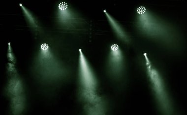 Sahne ışıkları. Bazı projektörler karanlıkta. Parlak renkli sahne ışığı karanlığı nüfuz eder. Işık aşamasından, rock konseri. Aydınlatma donanımları. Tiyatro aydınlatma sistemi üzerinde çeşitli projektörler