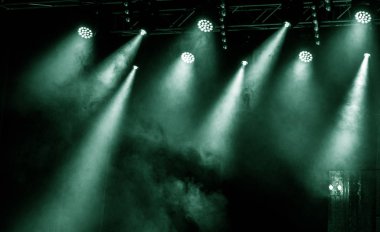 Sahne ışıkları. Bazı projektörler karanlıkta. Parlak renkli sahne ışığı karanlığı nüfuz eder. Işık aşamasından, rock konseri. Aydınlatma donanımları. Tiyatro aydınlatma sistemi üzerinde çeşitli projektörler