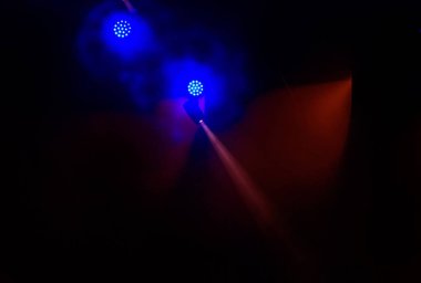 Sahne ışıkları. Bazı projektörler karanlıkta. Parlak renkli sahne ışığı karanlığı nüfuz eder. Işık aşamasından, rock konseri. Aydınlatma donanımları. Tiyatro aydınlatma sistemi üzerinde çeşitli projektörler