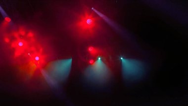 Sahne ışıkları. Bazı projektörler karanlıkta. Parlak renkli sahne ışığı karanlığı nüfuz eder. Işık aşamasından, rock konseri. Aydınlatma donanımları. Tiyatro aydınlatma sistemi üzerinde çeşitli projektörler