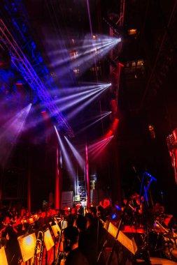 Sahne ışıkları. Bazı projektörler karanlıkta. Parlak renkli sahne ışığı karanlığı nüfuz eder. Işık aşamasından, rock konseri. Aydınlatma donanımları. Tiyatro aydınlatma sistemi üzerinde çeşitli projektörler