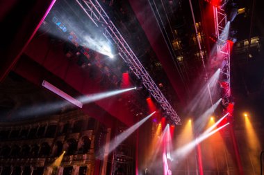 Sahne ışıkları. Bazı projektörler karanlıkta. Parlak renkli sahne ışığı karanlığı nüfuz eder. Işık aşamasından, rock konseri. Aydınlatma donanımları. Tiyatro aydınlatma sistemi üzerinde çeşitli projektörler