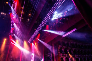 Sahne ışıkları. Bazı projektörler karanlıkta. Parlak renkli sahne ışığı karanlığı nüfuz eder. Işık aşamasından, rock konseri. Aydınlatma donanımları. Tiyatro aydınlatma sistemi üzerinde çeşitli projektörler