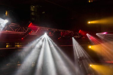 Sahne ışıkları. Bazı projektörler karanlıkta. Parlak renkli sahne ışığı karanlığı nüfuz eder. Işık aşamasından, rock konseri. Aydınlatma donanımları. Tiyatro aydınlatma sistemi üzerinde çeşitli projektörler