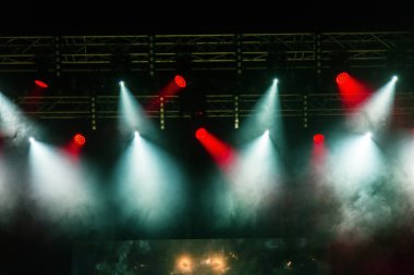 Sahne ışıkları. Bazı projektörler karanlıkta. Parlak renkli sahne ışığı karanlığı nüfuz eder. Işık aşamasından, rock konseri. Aydınlatma donanımları. Tiyatro aydınlatma sistemi üzerinde çeşitli projektörler