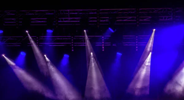舞台照明 暗闇の中で複数台のプロジェクター 明るい色のスポット ライトは 暗闇の中を浸透します ロック コンサートの舞台から光 照明器具 演劇的な照明システムに複数台のプロジェクター ロイヤリティフリーのストック写真