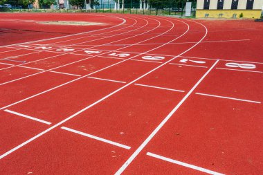 Koşu bandı Spor Stadyumu numaraları ile birlikte. Parça, çalıştıran, bir açık hava koşu bandı kırmızı spor alanında. Stadyum bend pistte izlemek