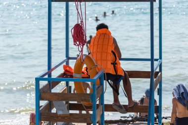 Odessa, Ukrayna - 19 Ağustos 2018: denizin içinde yıkananlara sonra cankurtaran watchtower sahilde üzerinde görünüyor. Turuncu bir hayat şamandıra ile kurtarıcı gözlem kulesi, denizin önünde oturur.