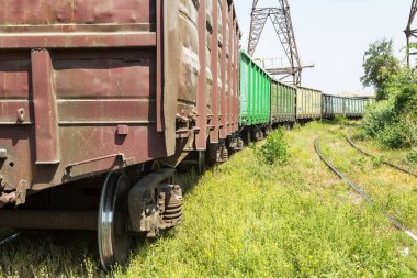 Kurulu gücü Endüstriyel depo nakliye araçları ile tren istasyonu. Renkli endüstriyel manzara. Demiryolu deposu. Demiryolu platformu. Ağır sanayi. Kargo taşımacılığı demiryolu araçları