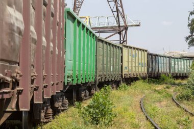 Kurulu gücü Endüstriyel depo nakliye araçları ile tren istasyonu. Renkli endüstriyel manzara. Demiryolu deposu. Demiryolu platformu. Ağır sanayi. Kargo taşımacılığı demiryolu araçları