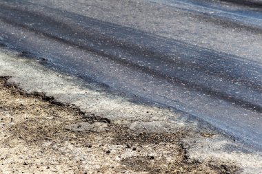 Bozuk yol çukurların ve nokta ile kıyılmış asfalt zarar görmüş. Çok kötü asfalt yol ile büyük trenche. Korkunç teknoloji yol asfalt üretim. Yumuşak asfalt ısı erir