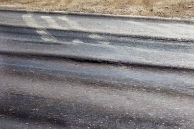 Bozuk yol çukurların ve nokta ile kıyılmış asfalt zarar görmüş. Çok kötü asfalt yol ile büyük trenche. Korkunç teknoloji yol asfalt üretim. Yumuşak asfalt ısı erir