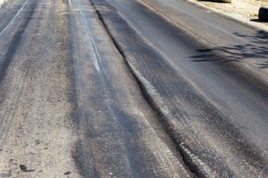 Bozuk yol çukurların ve nokta ile kıyılmış asfalt zarar görmüş. Çok kötü asfalt yol ile büyük trenche. Korkunç teknoloji yol asfalt üretim. Yumuşak asfalt ısı erir