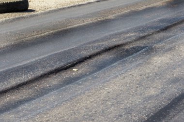 Bozuk yol çukurların ve nokta ile kıyılmış asfalt zarar görmüş. Çok kötü asfalt yol ile büyük trenche. Korkunç teknoloji yol asfalt üretim. Yumuşak asfalt ısı erir