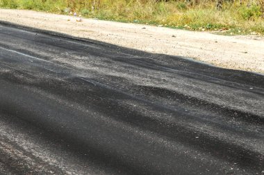 Bozuk yol çukurların ve nokta ile kıyılmış asfalt zarar görmüş. Çok kötü asfalt yol ile büyük trenche. Korkunç teknoloji yol asfalt üretim. Yumuşak asfalt ısı erir