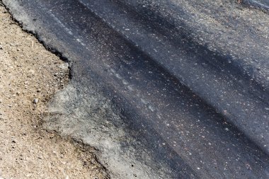 Bozuk yol çukurların ve nokta ile kıyılmış asfalt zarar görmüş. Çok kötü asfalt yol ile büyük trenche. Korkunç teknoloji yol asfalt üretim. Yumuşak asfalt ısı erir