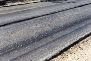 Bozuk yol çukurların ve nokta ile kıyılmış asfalt zarar görmüş. Çok kötü asfalt yol ile büyük trenche. Korkunç teknoloji yol asfalt üretim. Yumuşak asfalt ısı erir