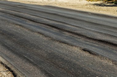 Bozuk yol çukurların ve nokta ile kıyılmış asfalt zarar görmüş. Çok kötü asfalt yol ile büyük trenche. Korkunç teknoloji yol asfalt üretim. Yumuşak asfalt ısı erir